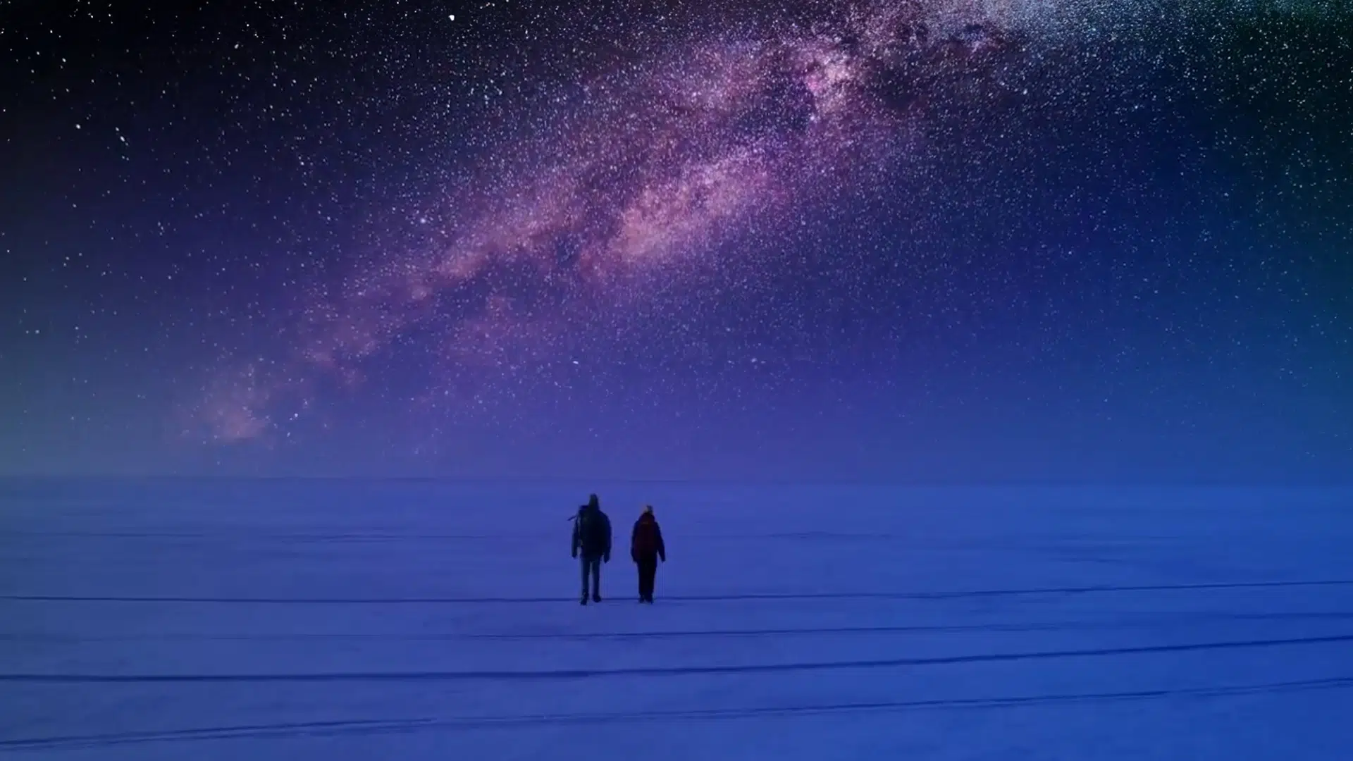 Image of two people walking on snow in the far North.